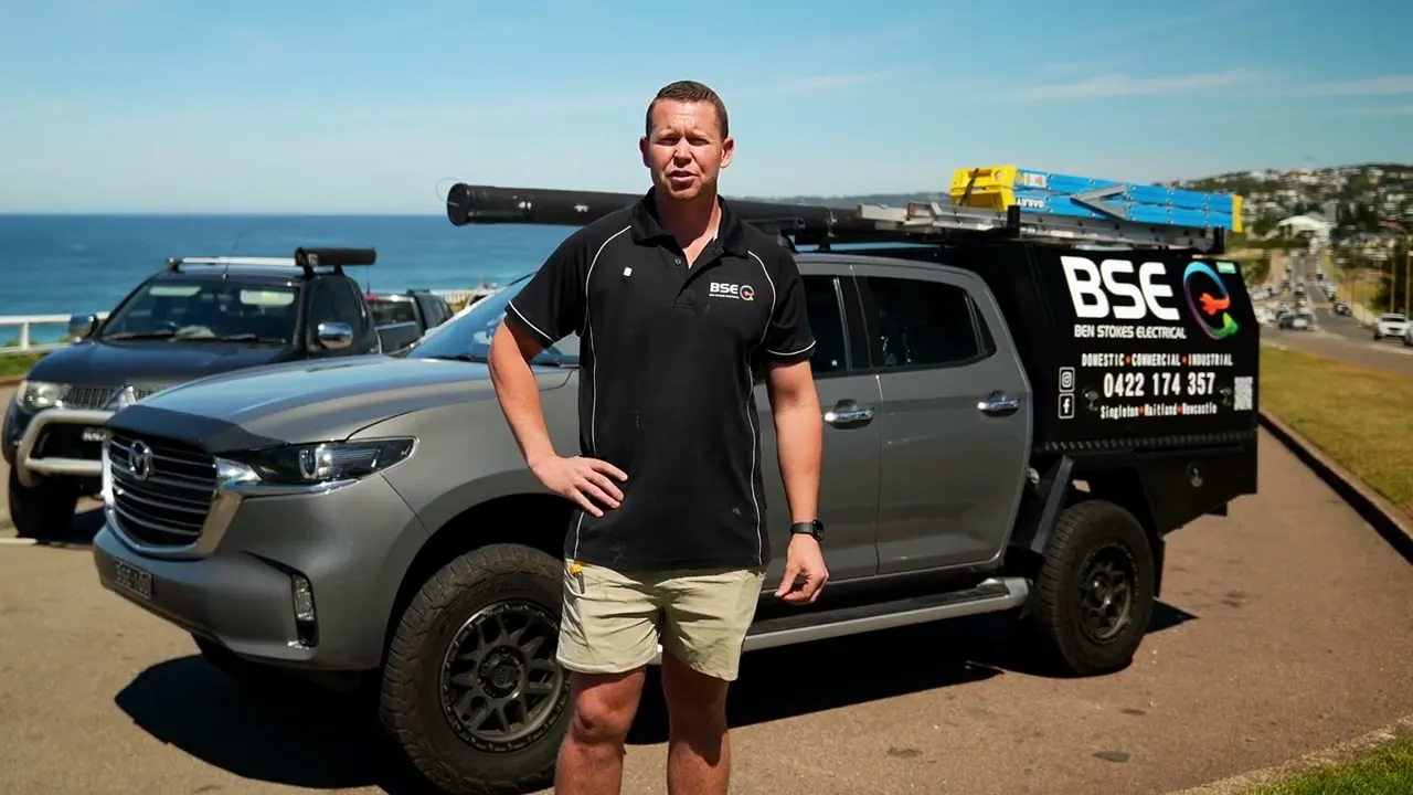 Ben standing beside the Ben Stokes Electrical ute on the coast