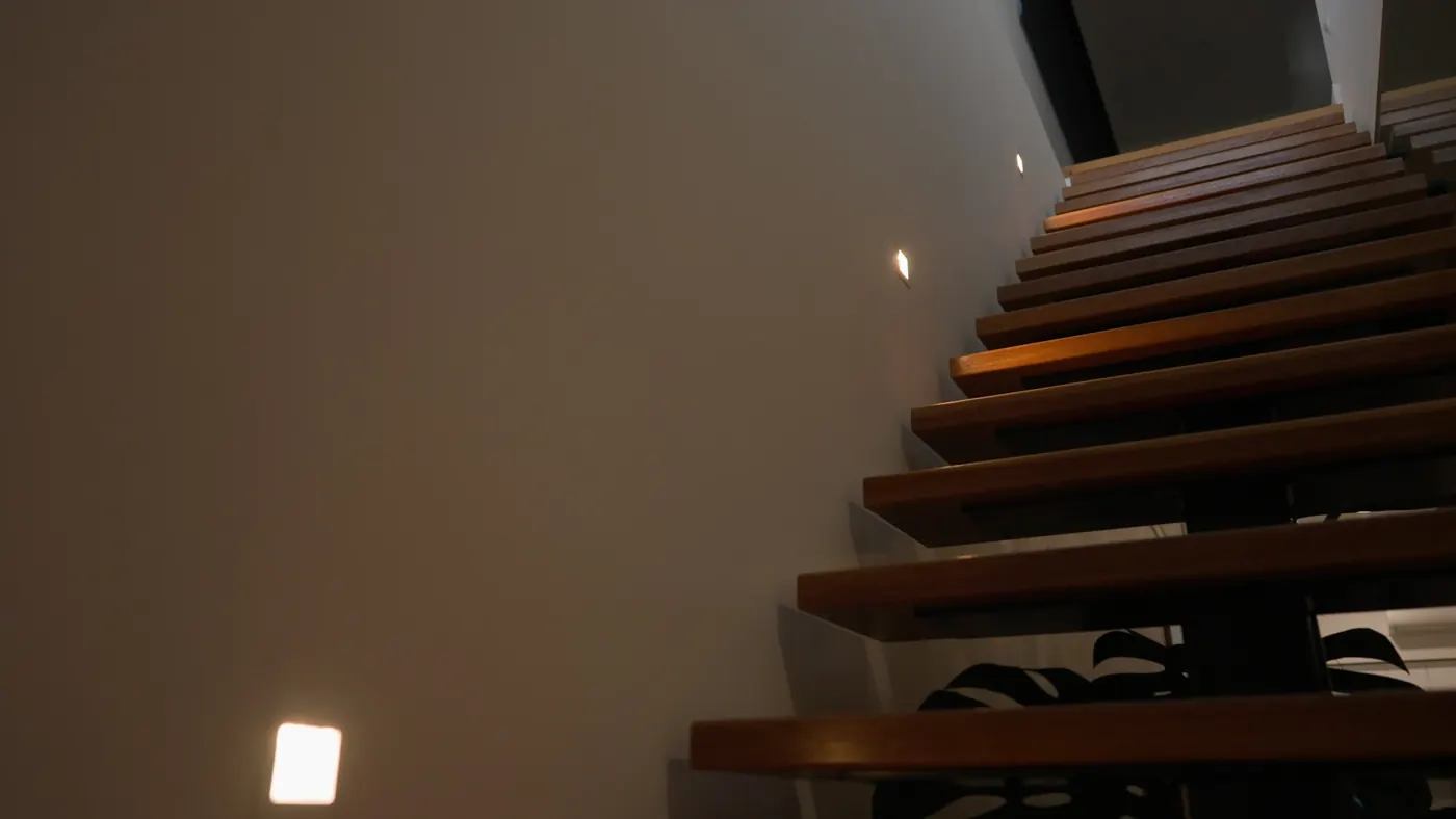 Step lights along a timber staircase, looking up