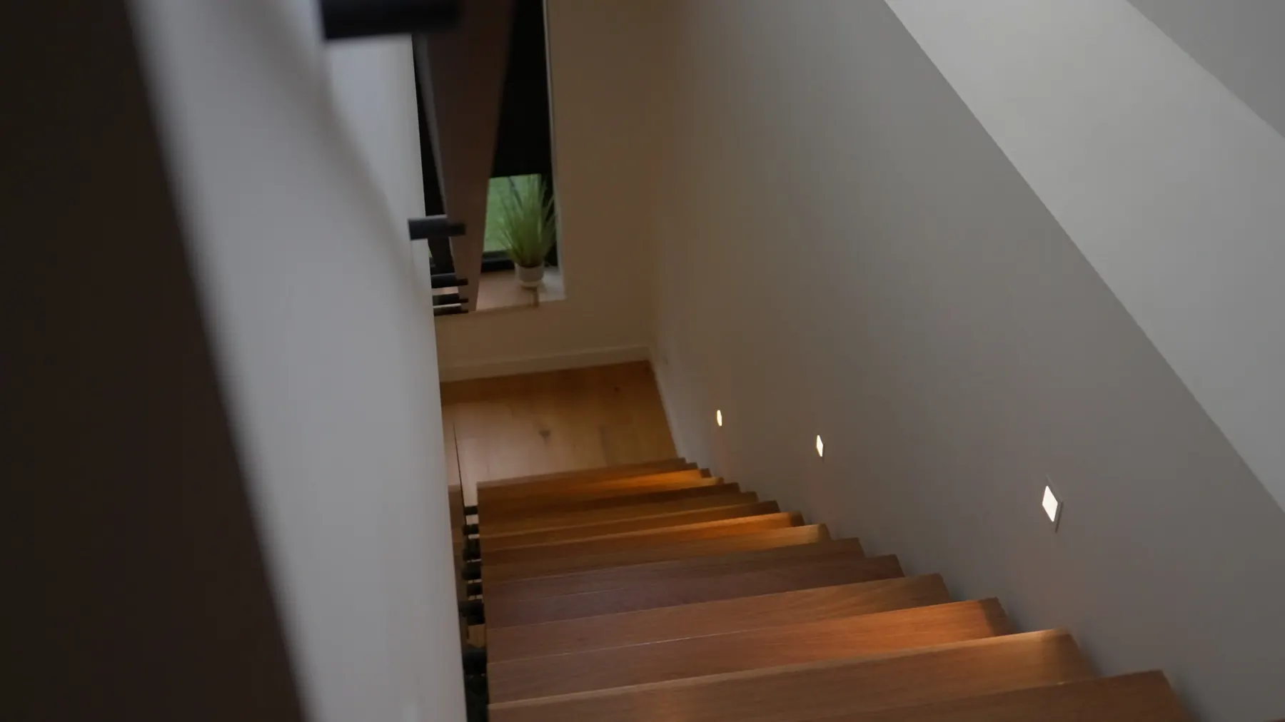 Warm LED step lights along a timber staircase